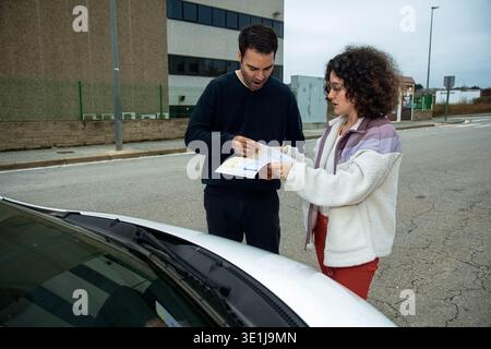 I conducenti scambiano i dettagli del rapporto di incidente dopo un incidente Foto Stock