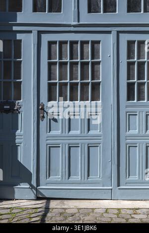 Doppia porta blu da un vecchio edificio di appartamenti, casa di città con finestre e pannelli di legno nel centro storico di Costanza, tradizionale granchio Foto Stock