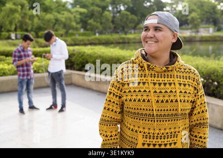 Ritratto di tre giovani uomini asiatici insieme di relax presso il parco a Bangkok, in Thailandia Foto Stock