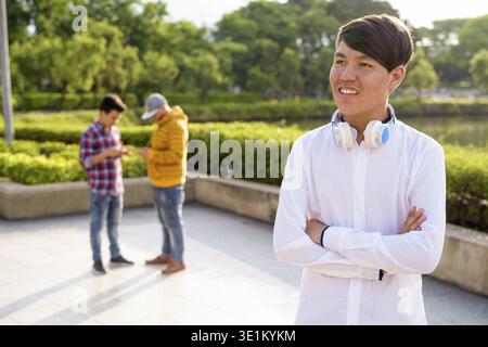 Ritratto di tre giovani uomini asiatici insieme di relax presso il parco a Bangkok, in Thailandia Foto Stock