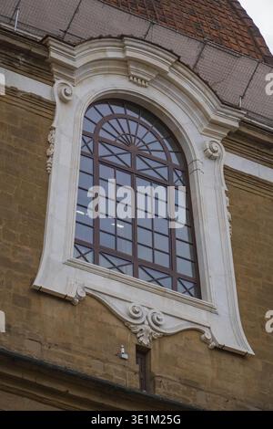 Basilica di San Lorenzo, San Lorenzo. Firenze, Italia. Particolare della finestra in marmo barocco circonda un muro in pietra arrugginita e un tetto in terracotta. Foto Stock