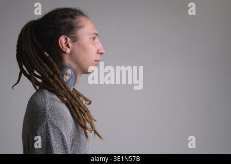 Foto in studio di un giovane e bellissimo uomo con dreadlock su sfondo bianco Foto Stock