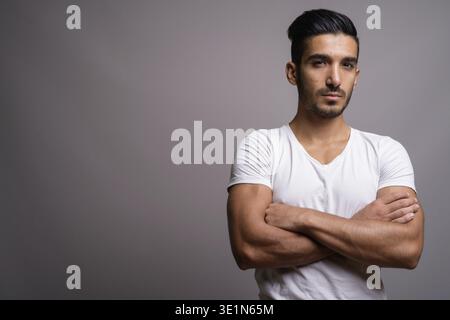 Studio shot di giovani bello il persiano uomo contro uno sfondo grigio Foto Stock
