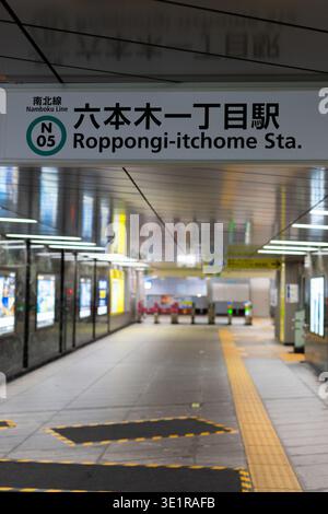 L'interno di una stazione vuota di Roppongi-itchome sulla linea Namboku a Tokyo, Giappone, mostra la segnaletica della stazione, i cancelli dei biglietti e la pavimentazione tattile. Foto Stock