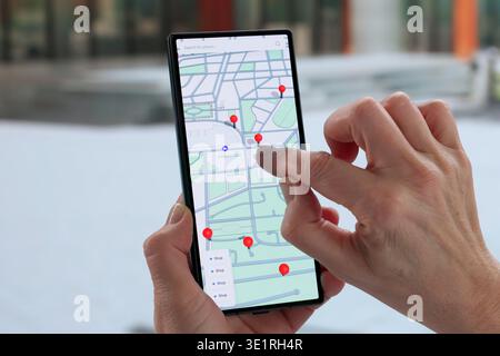 Esplorare la città con GPS, telefono in mano, Navigatore femminile. Foto Stock
