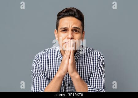 Giovane uomo che indossa Abbigliamento Casual supplica e chiede qualcosa Foto Stock