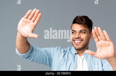 Sorridente Guy rendendo il telaio a mano qualcosa di visualizzazione Foto Stock
