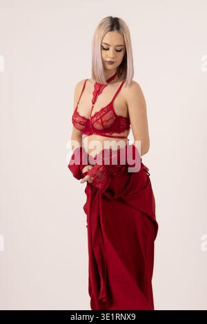 Donna che posa e guarda in basso in studio Foto Stock