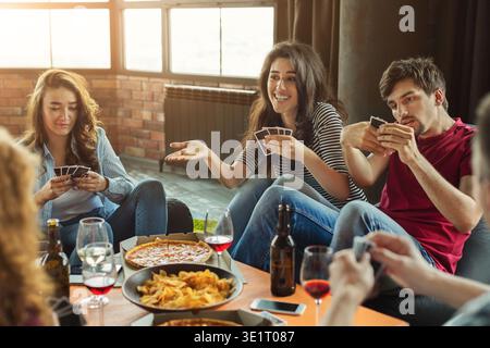 Felice gruppo di amici che giocano a carte Foto Stock