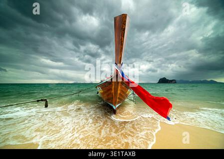 Barca a coda lunga sulla spiaggia, nuvole di pioggia scure sullo sfondo, isola di Koh Ngai, Mare delle Andamane, Provincia di Satun, Thailandia meridionale, Thailandia, Asia Foto Stock