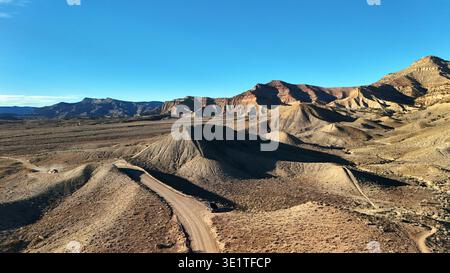 Vista aerea dell'aspro paesaggio desertico, dove il sole getta lunghe ombre, mettendo in risalto le texture del terreno arido, Fruita, Colorado, United S Foto Stock