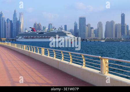 Vista della nave da crociera Carnival Splendor contro i grattacieli dello skyline di Marina District a Dubai, Emirati Arabi Uniti Foto Stock