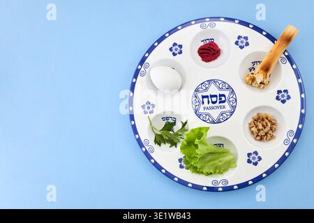 Piatto di sidro pasquale che mostra i tradizionali cibi simbolici su blu Foto Stock