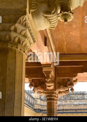 Colonna ornata in arenaria con intricate sculture che sostengono il soffitto del palazzo nell'architettura di Jaipur. I dettagli storici del Rajasthan mostrano la capitale scolpita e il de Foto Stock