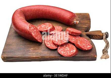 Sucuk turco intero e tagliato a fette (sujuk) su un tagliere rustico. Tradizionale salsiccia piccante e stagionata Foto Stock