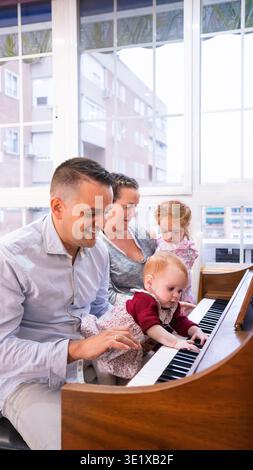 Famiglia felice che ascolta la musica con i propri figli a casa Foto Stock