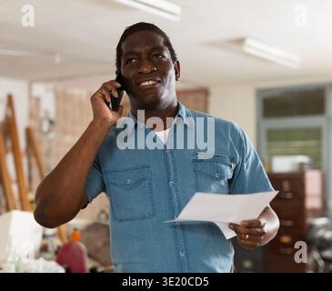 Uomo che ha conversazione telefonica in cantiere Foto Stock