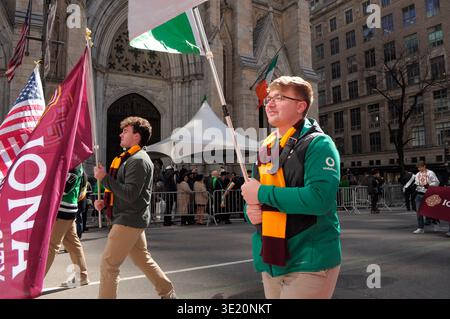 New York, Stati Uniti. 17 marzo 2026. Un partecipante alla parata marcia mentre sventura una bandiera irlandese alla parata del giorno di San Patrizio di New York fuori dalla cattedrale di San Patrizio sulla Fifth Avenue. La parata annuale che commemora la cultura irlandese attira agenti di polizia, vigili del fuoco, politici, bande e rivelatori nel centro di Manhattan, New York. Credito: SOPA Images Limited/Alamy Live News Foto Stock