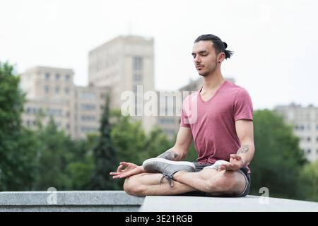 Uomo che pratica yoga a occhi chiusi all'aperto Foto Stock