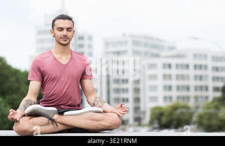 Uomo caucasico che pratica yoga in città Foto Stock