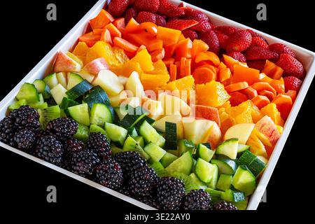 Disposizione colorata di frutta e verdura fresca su un piatto quadrato bianco. Foto Stock
