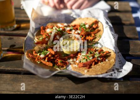 Tacos di strada con carne, coriandolo e cipolle serviti su un vassoio rivestito di carta con salsa verde. Bruxelles, Belgio Foto Stock