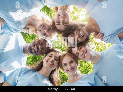 Persone felici in piedi insieme, vista dal basso Foto Stock