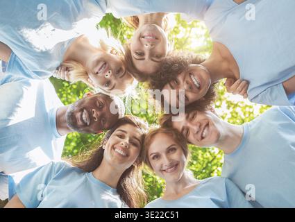 Persone felici in piedi insieme, vista dal basso Foto Stock