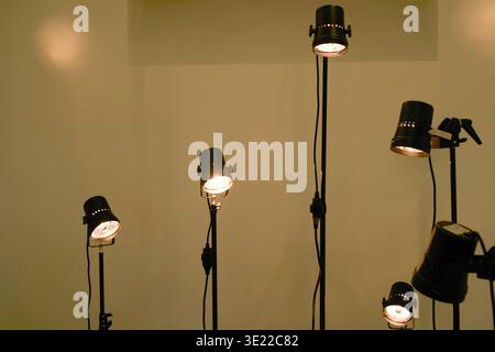 Sei faretti con lampadine incandescenti su piedistalli contro una parete semplice. Bruxelles, Belgio Foto Stock