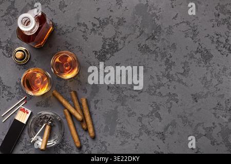 Due bicchieri con cognac, bottiglia e sigari Foto Stock
