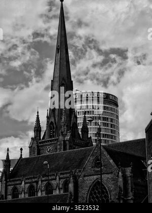 Foto in bianco e nero di San Martino nell'anello del Toro con la Rotonda che sorge alle spalle, catturando il contrasto tra la chiesa storica e la moderna Birmingham Foto Stock