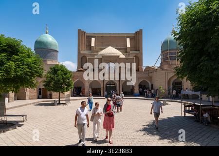 Tashkent (Toshkent), Uzbekistan (o'zbekiston) - 26 maggio 2025: I turisti camminano nel soleggiato cortile della storica Madrasa di Barakhan, parte del Khaz Foto Stock