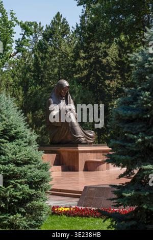 Tashkent (Toshkent), Uzbekistan (o'zbekiston) - 26 maggio 2025: Vista verticale del monumento di bronzo della madre addolorata circondata da alberi sempreverdi Foto Stock