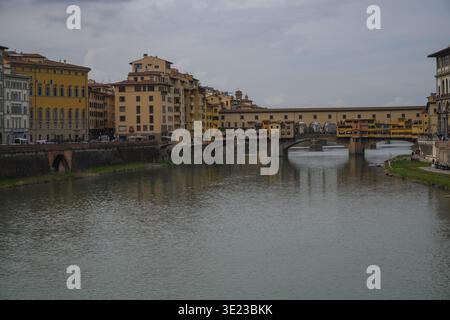 Ponte Vecchio, conosciuto per i negozi costruiti lungo di esso. L'architettura medievale attraversa il fiume Arno, Firenze, in Italia sotto cieli nuvolosi. Foto Stock