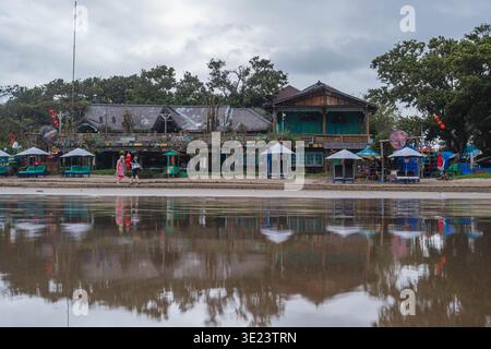 Beach Club e ombrelloni riflessi su Wet Sand Foto Stock