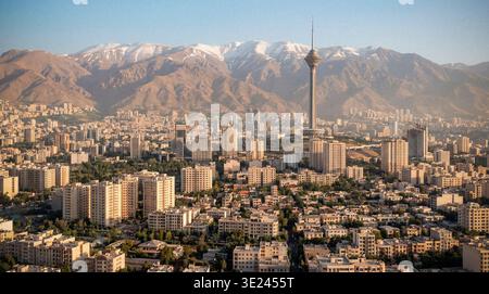 Ampio panorama aereo di Teheran, Iran, che mostra la proliferazione urbana e le principali reti stradali che conducono alla Torre Milad, con i Monti Alborz Foto Stock