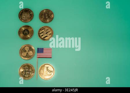 Una raccolta di varie criptovalute e una piccola bandiera americana su sfondo verde zecca, che rappresenta l'economia digitale. Foto Stock