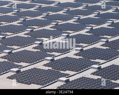 Questa vista aerea ravvicinata rivela un centro logistico con pannelli solari sul tetto progettati per l'efficienza energetica e l'uso di energie rinnovabili. Foto Stock