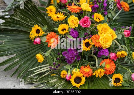 Festival De Flores - Antigua Guatemala - vibrante composizione floreale mista con girasoli, rose gialle, gerbera arancia e Asciroppi viola adagiati Foto Stock