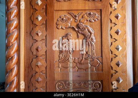 Aguacatan, Guatemala - intricato rilievo in legno che mostra il battesimo di Cristo con Giovanni Battista, motivo di colomba e bordi geometrici decorativi. Caldo Foto Stock