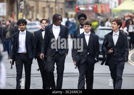 Giovani uomini che indossano un sub-fusc accademico che camminano per le strade di oxford per una cerimonia di laurea Foto Stock