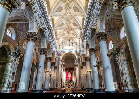 Splendido interno della cattedrale di San Giovanni Battista a Ragusa. La navata presenta ornati stucchi bianchi e dorati, colonne corinzie e ceili a volta Foto Stock