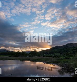 vista sopraelevata del tramonto sul lago windermere a waterhead ambleside con colline lontane Foto Stock