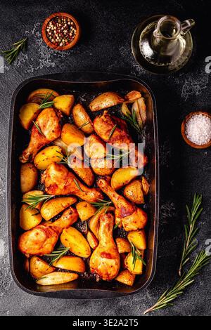 Cosce di pollo arrosto con patate e rosmarino. Vista dall'alto. Foto Stock