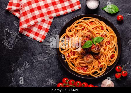 Spaghetti con polpette e salsa di pomodoro su sfondo di pietra, vista dall'alto Foto Stock