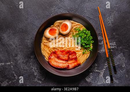 Una ciotola di ramen con spaghetti, carne e cipolle verdi, vista dall'alto. Foto Stock