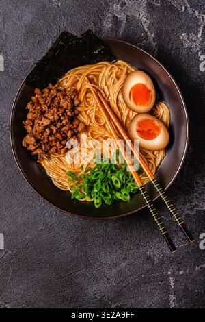 Una ciotola di ramen con spaghetti, carne e cipolle verdi, vista dall'alto. Foto Stock