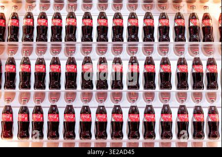 Milano, Lombardia, Italia - venerdì 13, 2026: Bottiglie per bevande a marchio Coca Cola Olympic Edition sugli scaffali espositivi, creando un pattern ricorrente Foto Stock