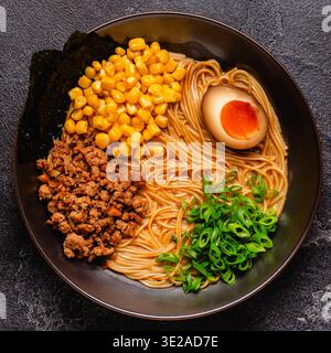 Una ciotola di ramen con spaghetti, carne e cipolle verdi, vista dall'alto. Foto Stock