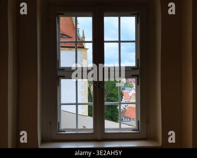 Vista attraverso una classica finestra a reticolo del Castello di Colditz che si affaccia sulla città sassone, pittoresco panorama sui tetti rossi Foto Stock